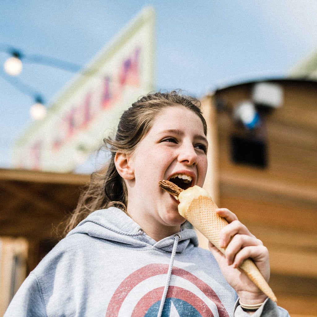Girl eating ice cream in front of Baboo kiosk at Morcombelake