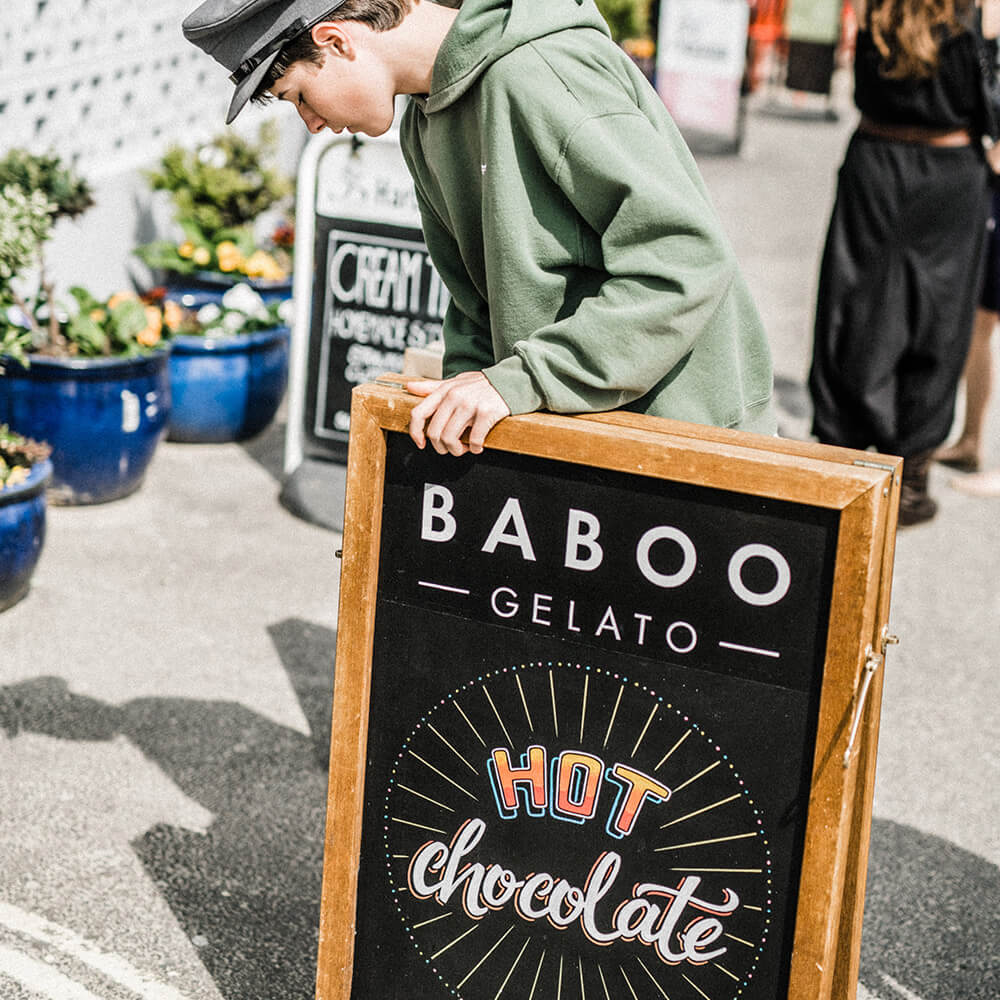 Boy putting out hot chocolate sign