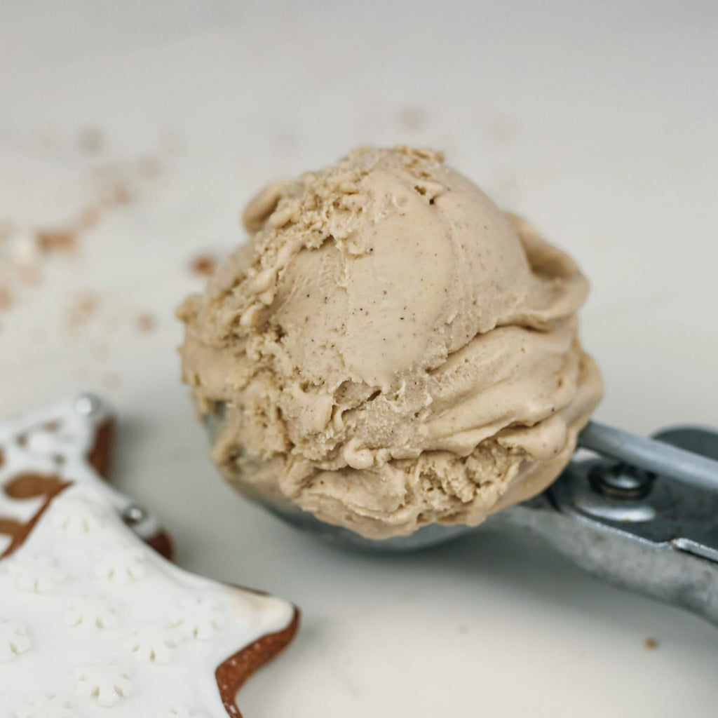 Gingerbread gelato on a scoop close up and in left hand corner a gingerbread iced star